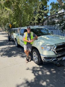 River District Clean Team Supervisor standing in front of a branded River District truck with trees in the background.